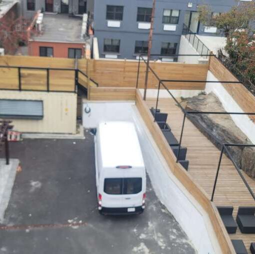The rear ground level pergolas with seating and the elevated area and the container top at The Outer Space (Bronx, NY) outdoor event venue. It is available for a private family gathering or party with friends.